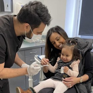 Dentist examining young child with parent at Windsor Dental Practice Leicester