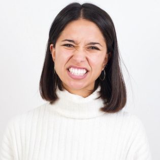 Woman experiencing tooth pain needing urgent extraction at Windsor Dental Practice Leicester